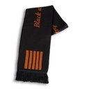 A black scarf with gold text and vertical stripes on it, fringed at the ends.
